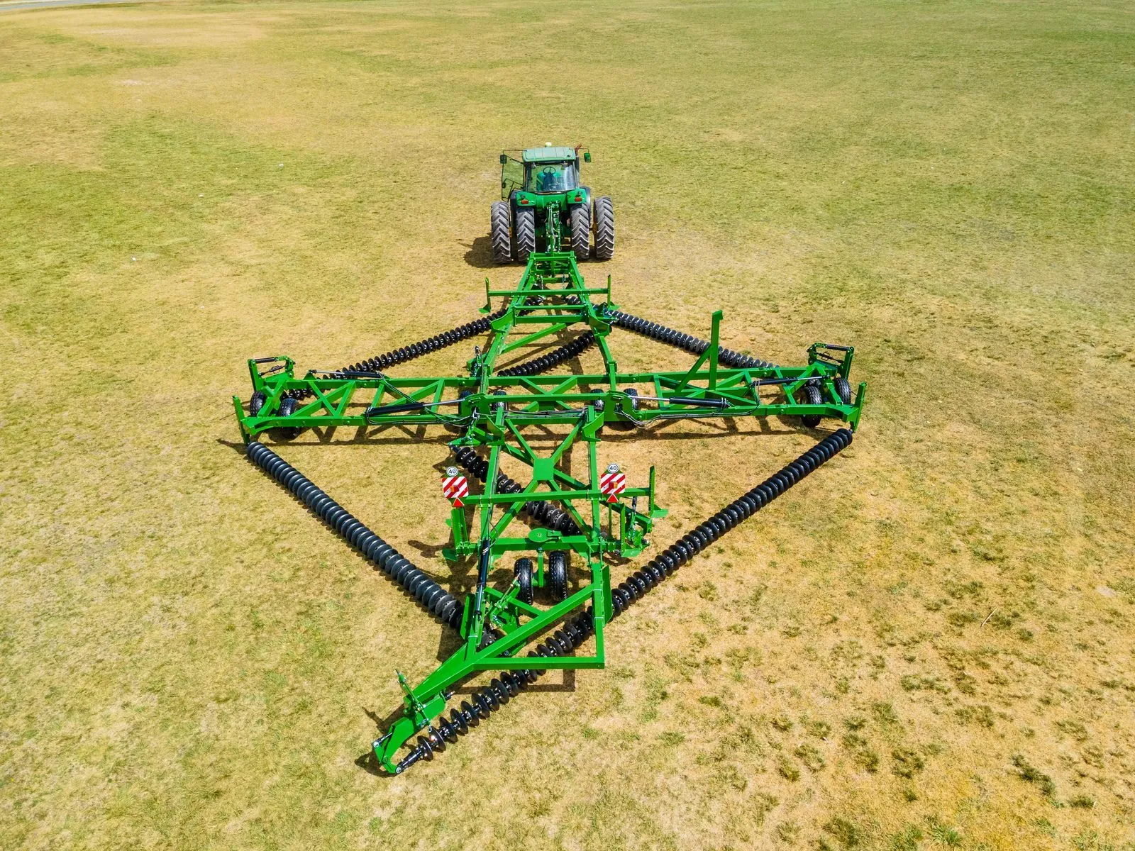 Vista aérea de la Rastra Diamante Evolution III desplegada detrás del tractor, portada del folleto